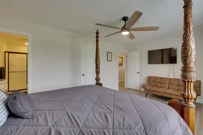 a bedroom with a bed with a ceiling fan and a couch at Hot Tub, Lake Access, and Dock Port Clinton Retreat in Port Clinton