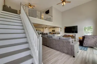 a living room with a staircase and a couch at Hot Tub, Lake Access, and Dock Port Clinton Retreat in Port Clinton
