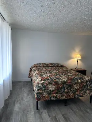 a bedroom with a bed and a lamp on a floor at CITY VIEW MOTEL in Centerville