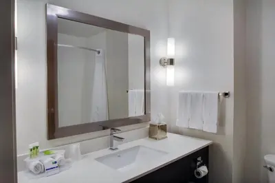 a white bathroom with a sink and a mirror at Holiday Inn Express Sidney by IHG in Sidney