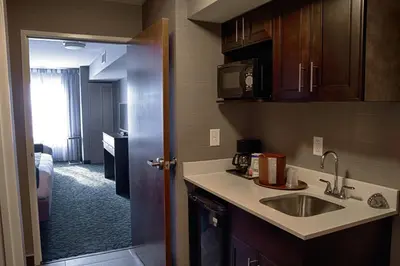 a kitchen with a sink and a door to a room at Holiday Inn Express Sidney by IHG in Sidney