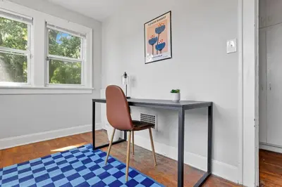 a desk in a room with a chair and a rug at The Champion Abode 2 in Columbus