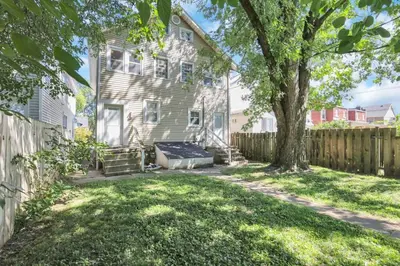 a house with a fence and a tree at The Champion Abode 2 in Columbus