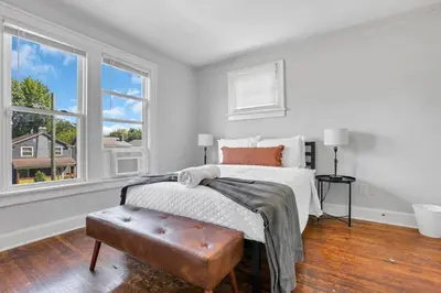a bedroom with a bed and two windows at The Champion Abode 2 in Columbus