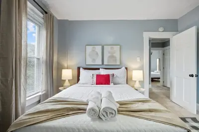 a bedroom with a large bed with towels on it at The Indiana Stunner in Columbus