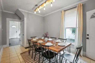a dining room with a wooden table and black chairs at The Indiana Stunner in Columbus