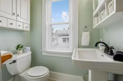 a bathroom with a toilet and a sink and a window at The Indiana Stunner in Columbus