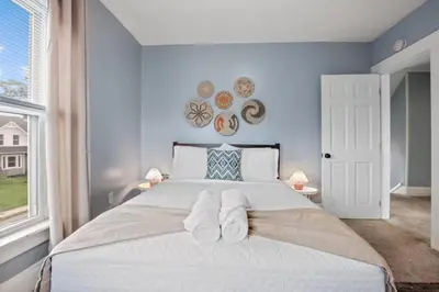a bedroom with a large bed with blue walls at The Indiana Stunner in Columbus