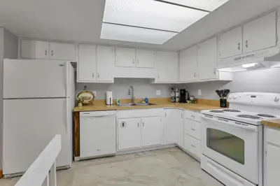 a kitchen with white cabinets and white appliances at The Highmeadow Retreat in Gahanna
