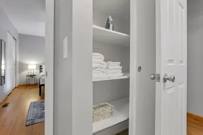 a white closet with white towels on shelves at The Highmeadow Retreat in Gahanna