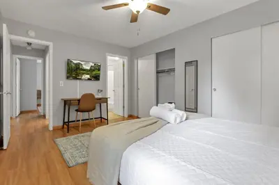 a white bedroom with a bed and a desk at The Highmeadow Retreat in Gahanna