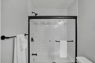 a bathroom with a shower and a toilet with towels at The Schumacher Townhouse - 2 BR in Columbus
