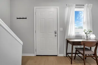 a white door in a room with a table and a window at The Schumacher Townhouse - 2 BR in Columbus