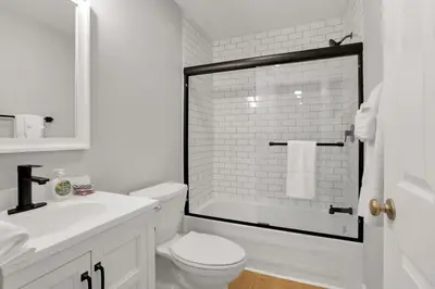 a white bathroom with a toilet and a sink at The Schumacher Place - NEW 2 BR in Columbus