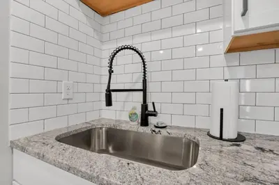 a kitchen sink with a faucet on a counter at The Schumacher Place - NEW 2 BR in Columbus