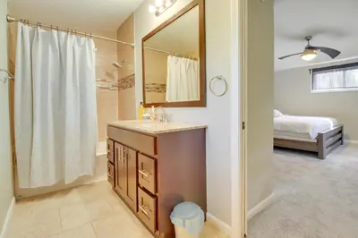 a bathroom with a sink and a mirror and a bed at 5 Mi to The USAF Museum Dayton Home, Walk to Park in Dayton