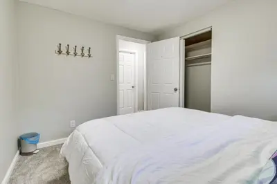 a bedroom with a white bed and a closet at 5 Mi to The USAF Museum Dayton Home, Walk to Park in Dayton