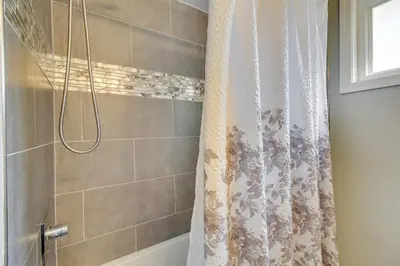 a shower with a white shower curtain in a bathroom at 5 Mi to The USAF Museum Dayton Home, Walk to Park in Dayton