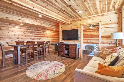a living room with a couch and a television in a log cabin at Fern Woods A modern take on Hocking Hills cabins in McArthur
