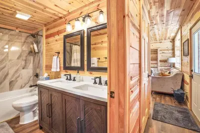 a bathroom with a sink and a toilet and a tub at Fern Woods A modern take on Hocking Hills cabins in McArthur