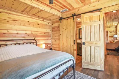 a bedroom with a bed in a log cabin at Fern Woods A modern take on Hocking Hills cabins in McArthur