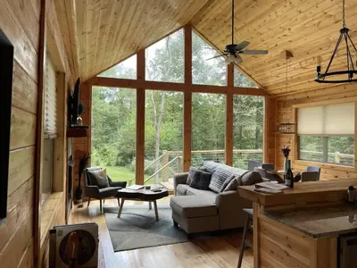 a living room with a couch and a table at Fern Haven A modern take on Hocking Hills cabins in McArthur