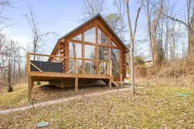 a small log cabin with a large window at Fern Haven A modern take on Hocking Hills cabins in McArthur