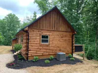 a log cabin in the woods with a window at Fern Haven A modern take on Hocking Hills cabins in McArthur