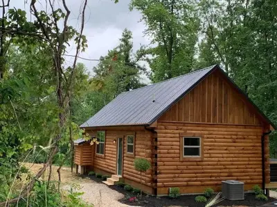 a log cabin with a metal roof at Fern Haven A modern take on Hocking Hills cabins in McArthur