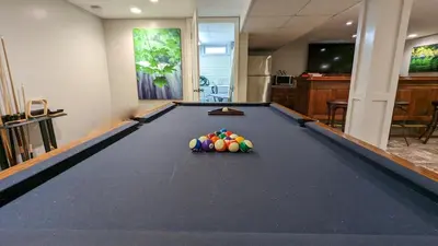 a pool table with balls on it in a room at 5 Bedroom Family Gathering Home with Indoor Hot Tub in Huron
