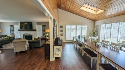 a living room with a kitchen and a living room with a table at 5 Bedroom Family Gathering Home with Indoor Hot Tub in Huron