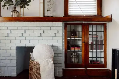 a white brick fireplace with a chair in front of it at Stunning 3BR - Near Cleveland Clinic Main Campus in Cleveland Heights