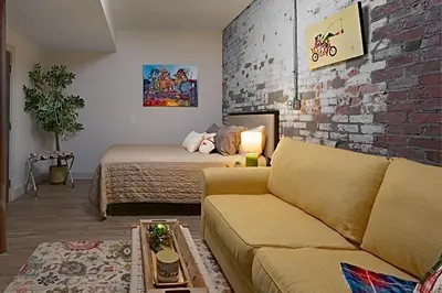 a living room with a couch and a brick wall at The 418. An 1866 Build with Modern Comforts in Fort Wayne