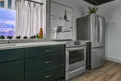 a kitchen with a stainless steel refrigerator and a sink at The 418. An 1866 Build with Modern Comforts in Fort Wayne