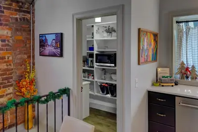 a kitchen with a door open to a pantry at The 418. An 1866 Build with Modern Comforts in Fort Wayne