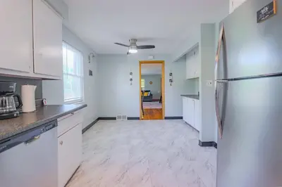 a kitchen with white cabinets and a refrigerator at Charming 2 Bed Room in Cleveland in Cleveland Heights