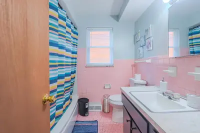 a pink bathroom with a sink and a toilet at Charming 2 Bed Room in Cleveland in Cleveland Heights