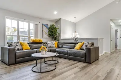 a living room with a leather couch and a table at Cozy Ohio Home - Deck, Arcade Games and Near Golfing in Cincinnati