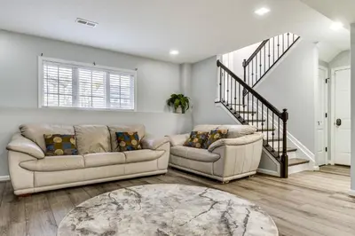 a living room with two couches and a staircase at Cozy Ohio Home - Deck, Arcade Games and Near Golfing in Cincinnati