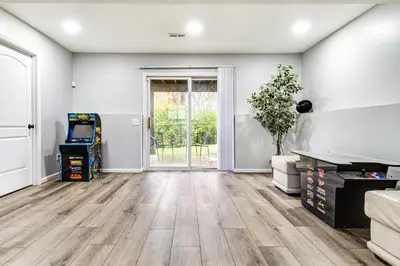 an empty living room with wood floors and a sliding glass door at Cozy Ohio Home - Deck, Arcade Games and Near Golfing in Cincinnati