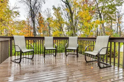 a group of four chairs sitting on a deck at Cozy Ohio Home - Deck, Arcade Games and Near Golfing in Cincinnati