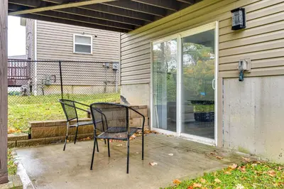 two chairs sitting on a porch next to a window at Cozy Ohio Home - Deck, Arcade Games and Near Golfing in Cincinnati