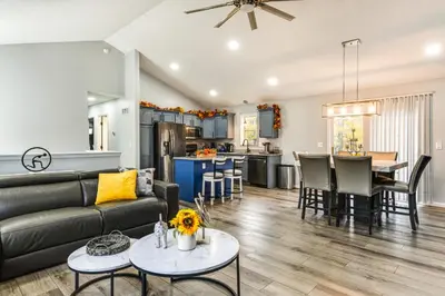 a living room and kitchen with a couch and a table at Cozy Ohio Home - Deck, Arcade Games and Near Golfing in Cincinnati