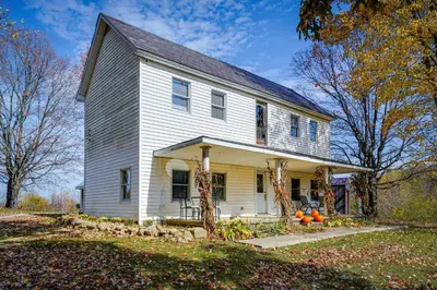 a white house with a gambrel roof at Spacious and Inviting Jackson Getaway with Fireplace! in Jackson