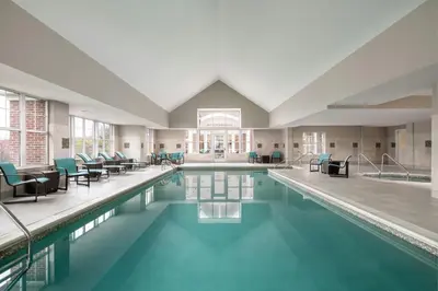 a swimming pool with chairs and tables in a building at Residence Inn by Marriott Akron Fairlawn in Fairlawn