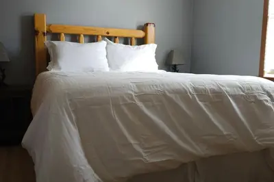 a large bed with white sheets and pillows at GameRoom, HotTub, Piano, 5mi to OldManCave - Hocking Hills Copper House in Laurelville