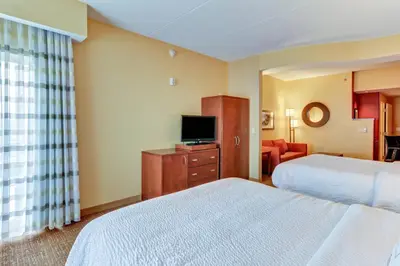 a hotel room with two beds and a television at Courtyard by Marriott Bridgeport Clarksburg in Bridgeport