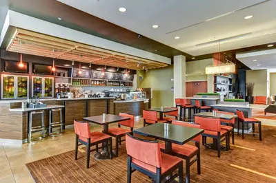 a restaurant with tables and chairs and a bar at Courtyard by Marriott Bridgeport Clarksburg in Bridgeport