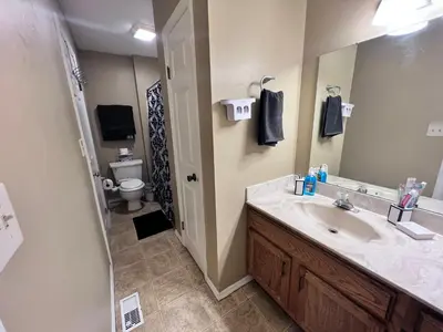 a bathroom with a sink and a toilet and a mirror at The Cozy Townhouse WPAFB & WSU in Fairborn