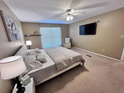 a bedroom with a bed and a ceiling fan at The Cozy Townhouse WPAFB & WSU in Fairborn